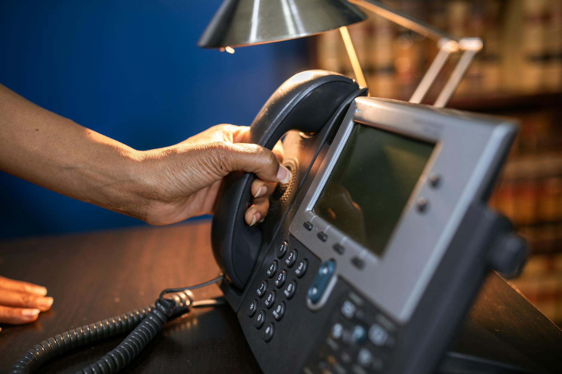 Hand picking up a telephone handset in a restaurant